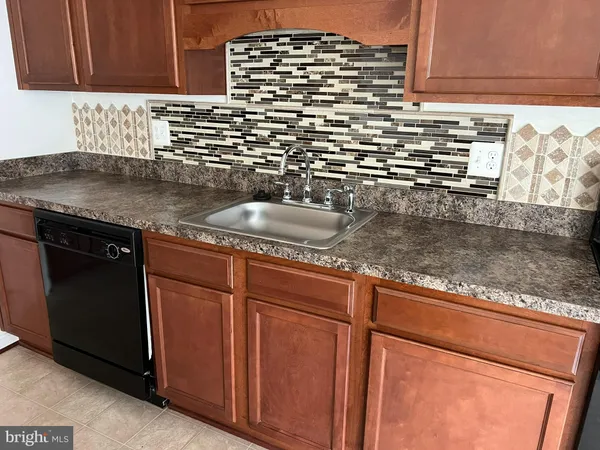 a kitchen with granite countertop a sink and a stove