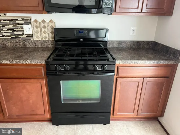 a kitchen with stainless steel appliances granite countertop a stove and a microwave