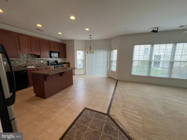 a kitchen with stainless steel appliances granite countertop a refrigerator a stove a sink and a microwave