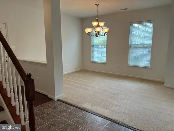 an empty room with chandelier and windows