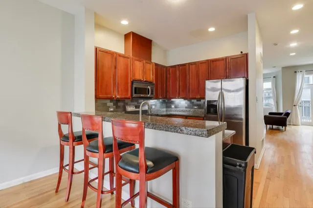 a kitchen with granite countertop a stove top oven microwave and cabinets