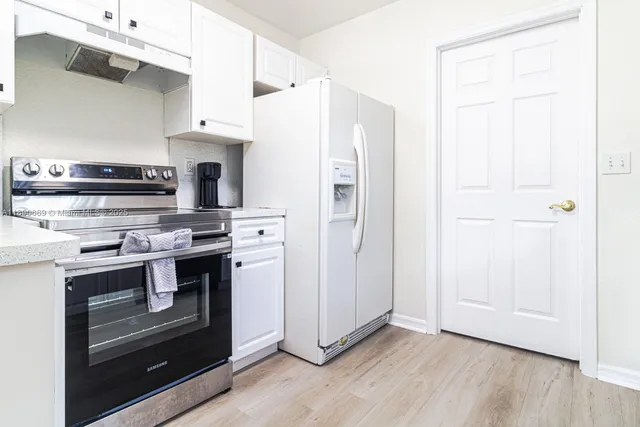 a kitchen with stainless steel appliances a stove a microwave and a refrigerator