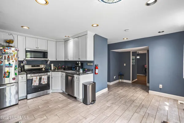 a kitchen with stainless steel appliances granite countertop a refrigerator and a stove top oven