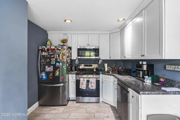 a kitchen with stainless steel appliances granite countertop a refrigerator and a stove top oven