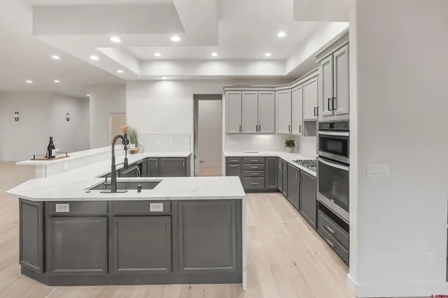 a kitchen with kitchen island a sink stainless steel appliances and cabinets