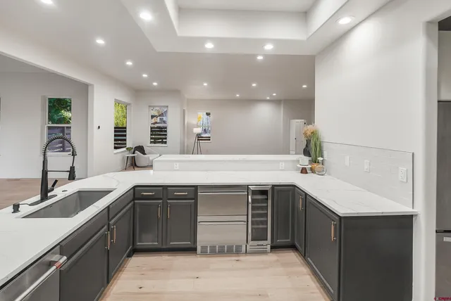 a kitchen with a sink and a stove top oven with wooden floor