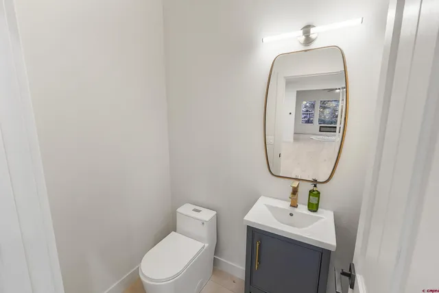 a bathroom with a toilet a sink and mirror