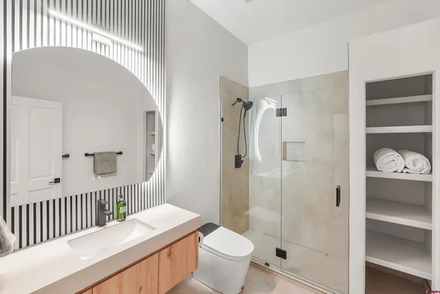 a bathroom with a sink a toilet and shower