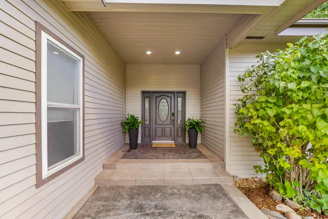 a hallway with potted plants in front of door