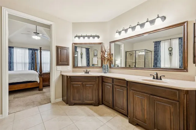 a spacious en suite bathroom with a sink a vanity and mirror