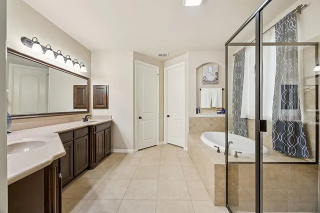 a spacious bathroom with a bathtub sink and mirror