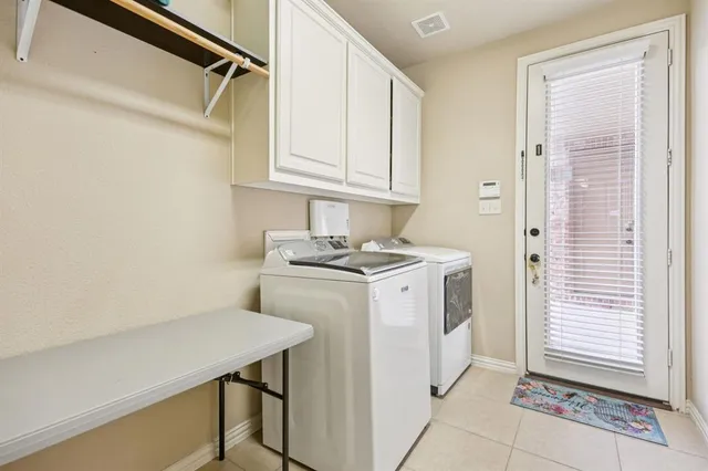 a utility room with cabinets washer and dryer