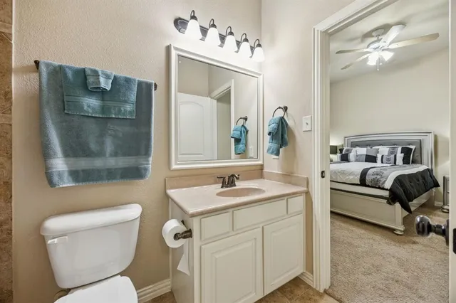 a bathroom with a granite countertop toilet and a mirror