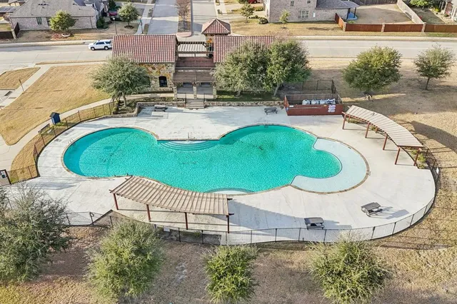 an aerial view of a house with outdoor space and swimming pool
