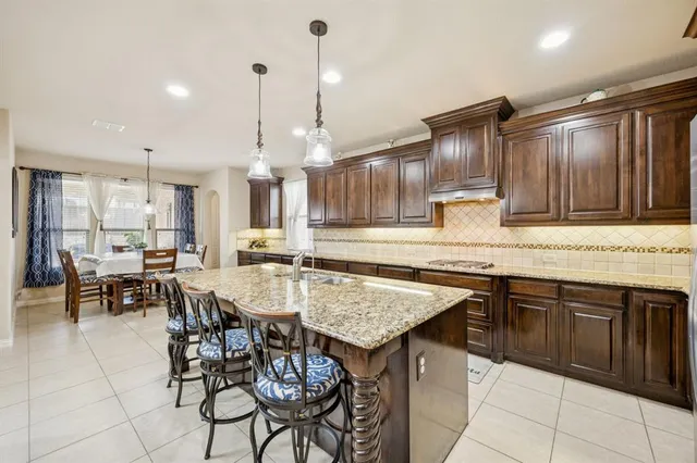 a kitchen with kitchen island granite countertop wooden cabinets and a refrigerator