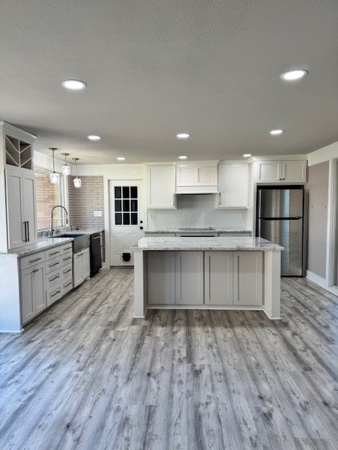 3500 Doris Street Bay City, TX 77414 - Photo 12 of 22 a large kitchen with stainless steel appliances granite countertop a large center island a stove a refrigerator white cabinets and wooden floor