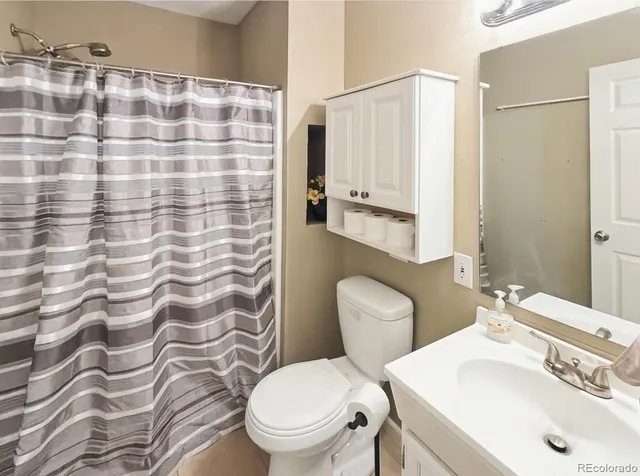 a bathroom with a sink a toilet and shower curtain