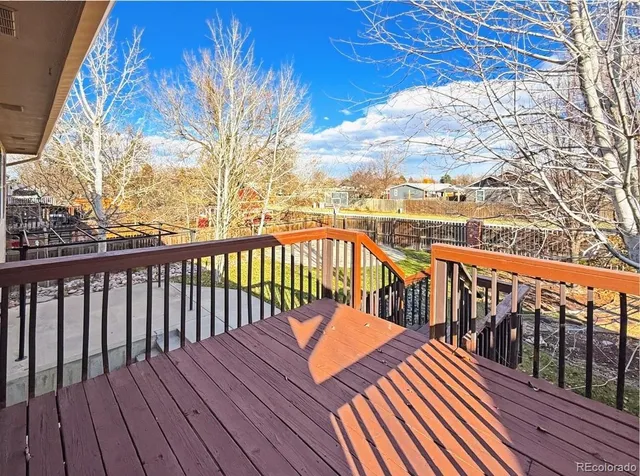 a view of balcony with wooden floor and fence