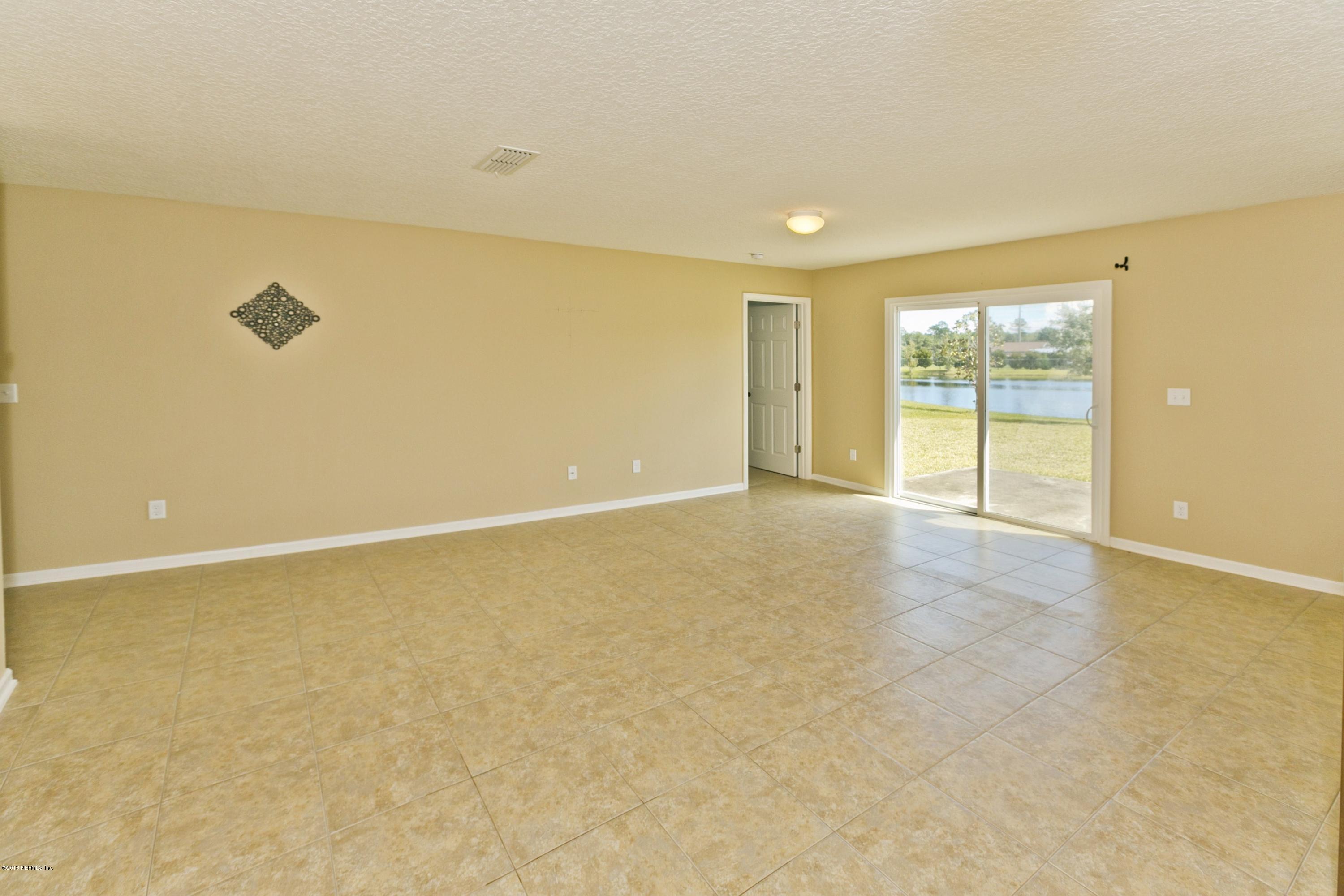 76 North Twin Maple Road St. Augustine, FL 32084 - Photo 3 of 21 an empty room with wooden floor and windows