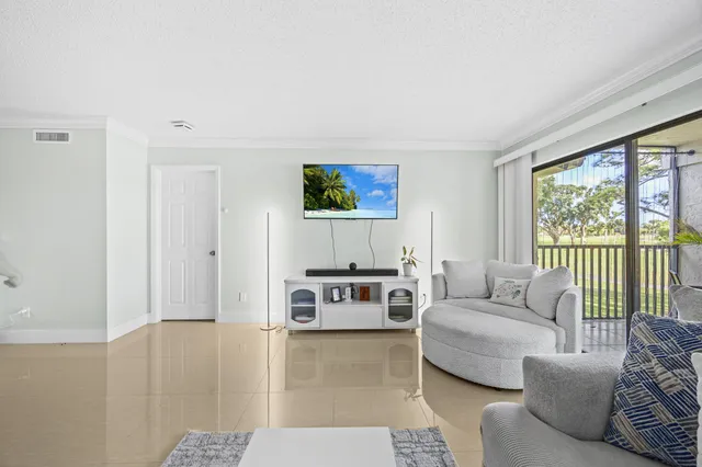 a view of a house with a big yard and palm trees