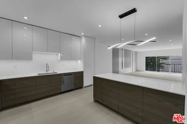 a large kitchen with kitchen island a sink stainless steel appliances and a counter top space