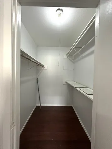 a view of walk in closet with empty racks