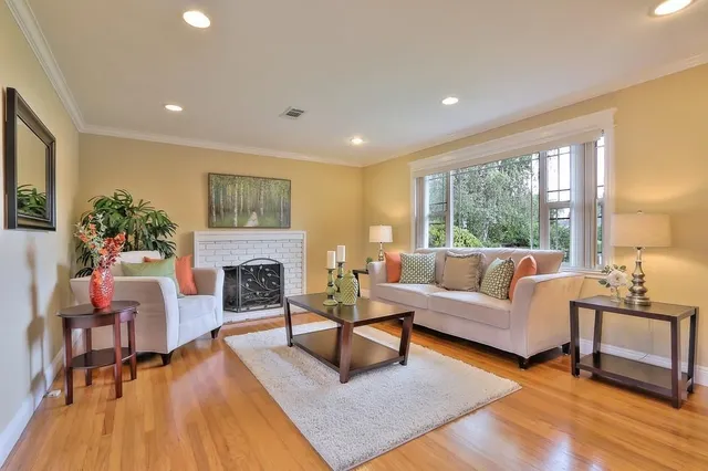 a living room with fireplace furniture and a large window