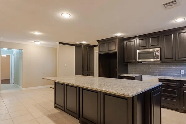 a kitchen with kitchen island a counter top space cabinets and stainless steel appliances