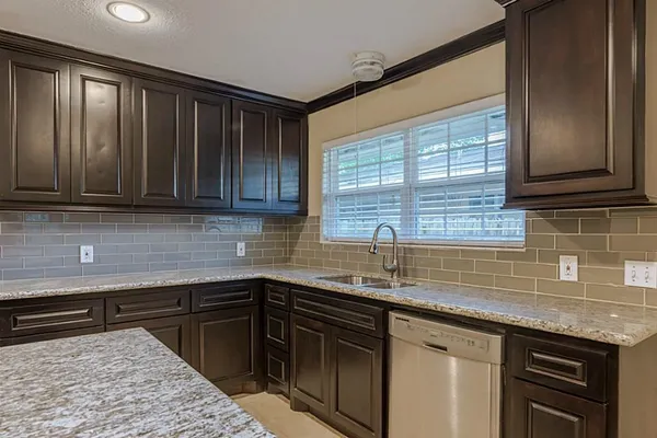 a kitchen with stainless steel appliances granite countertop wooden cabinets a sink and dishwasher