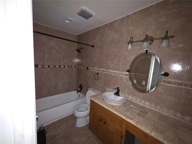 a bathroom with a double vanity sink toilet and shower