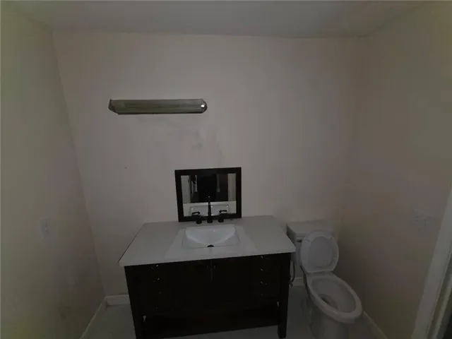 a bathroom with a toilet a sink and mirror