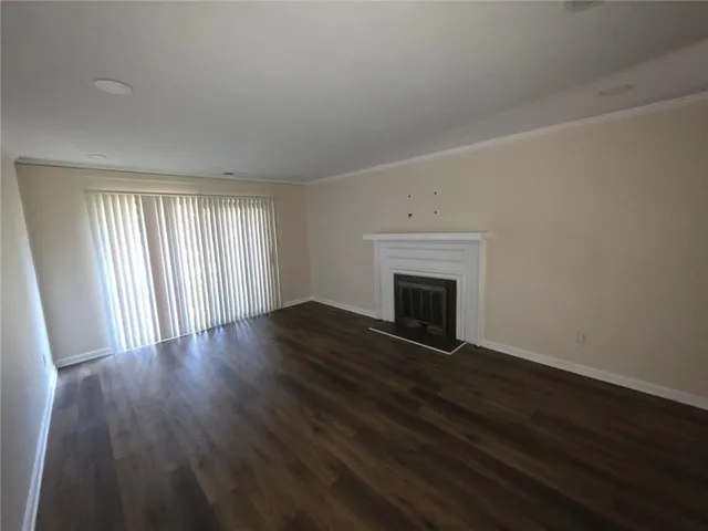 a view of empty room with wooden floor and fireplace