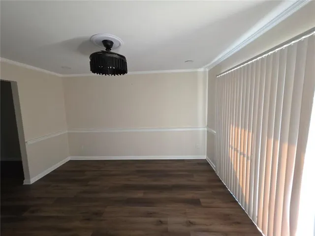 a view of a room with wooden floor and a window