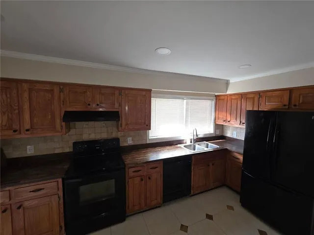a kitchen with granite countertop a refrigerator and a sink