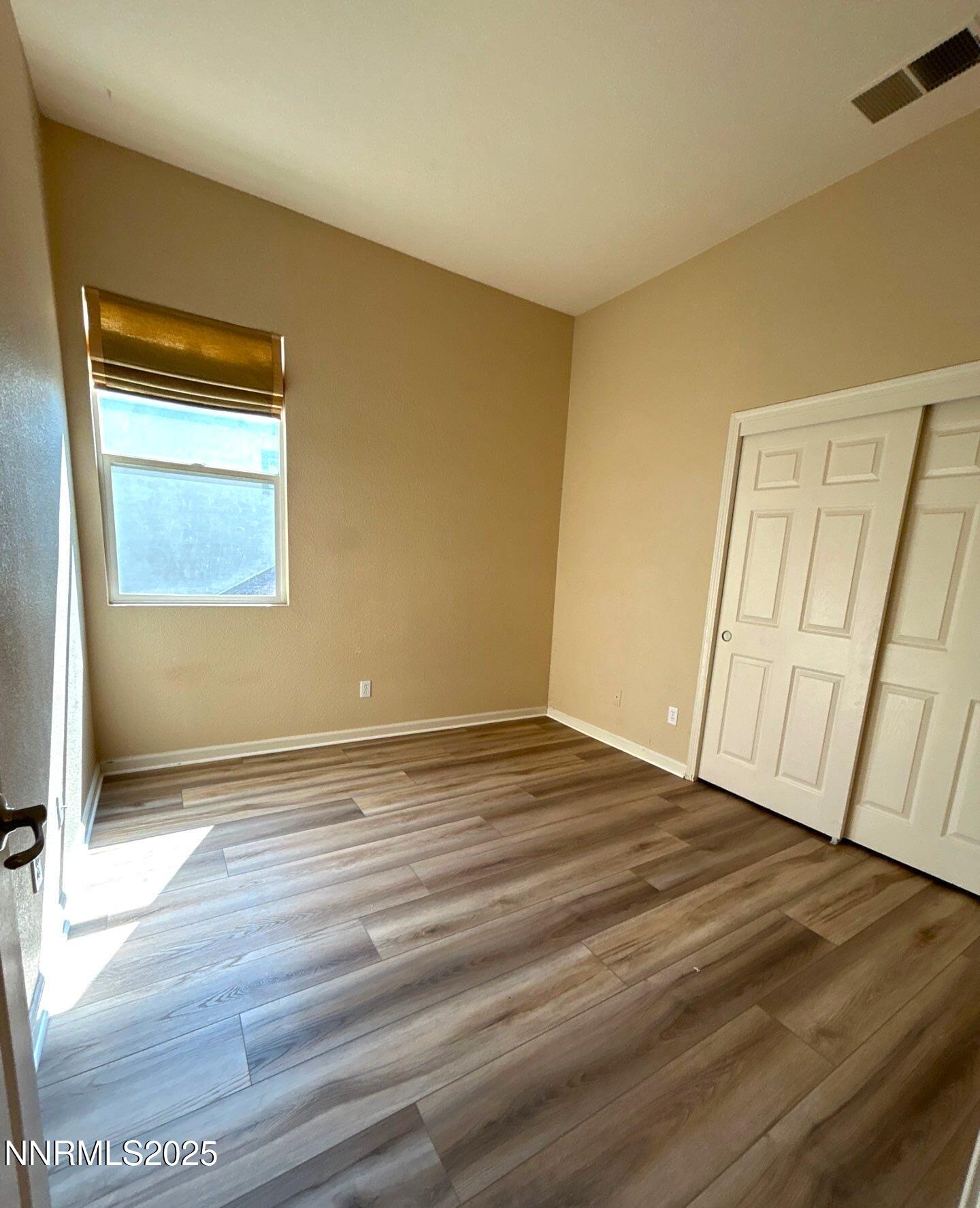 1484 Cloud Peak Drive Sparks, NV 89436 - Photo 13 of 16 a view of an empty room with wooden floor and a window