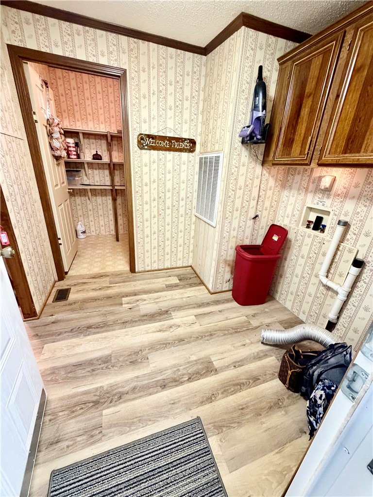 1549 Greenfield Road Westminster, SC 29693 - Photo 13 of 49 A dedicated laundry space offers convenience with wood-look flooring and ample cabinetry.