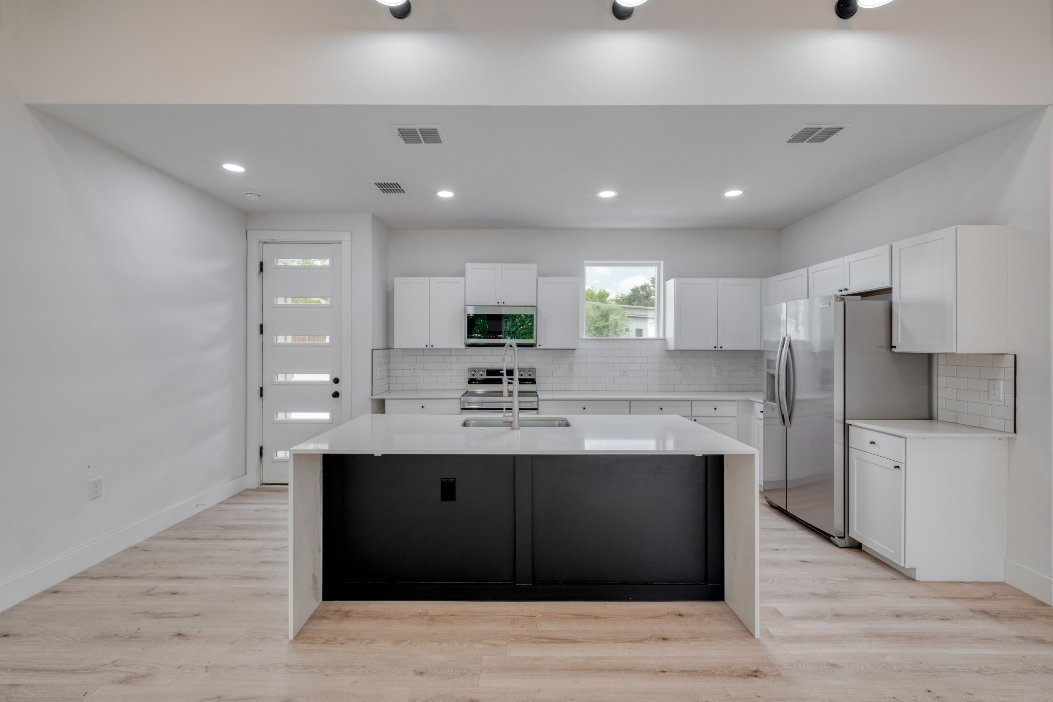 5211 Rob-Scott Street Austin, TX 78721 - Photo 7 of 24 A sleek island anchors this bright kitchen, complete with stainless steel appliances and abundant cabinetry.