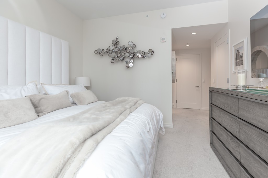 1 Franklin Street, Unit 1004 Boston, MA 02110 - Photo 16 of 24 a bedroom with a bed and a chandelier