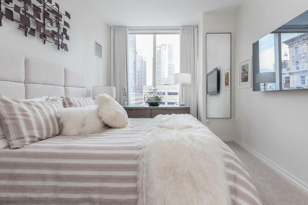 1 Franklin Street, Unit 1004 Boston, MA 02110 - Photo 17 of 24 a bedroom with a large bed and a large window