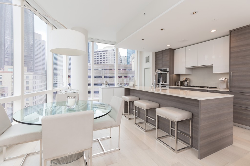 1 Franklin Street, Unit 1004 Boston, MA 02110 - Photo 4 of 24 a dining room with furniture a large window and stainless steel appliances