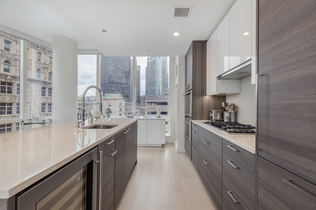 1 Franklin Street, Unit 1004 Boston, MA 02110 - Photo 5 of 24 a kitchen with stainless steel appliances a sink stove and cabinets