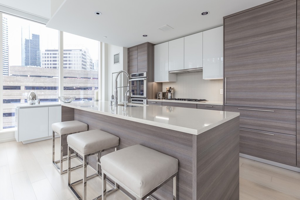 1 Franklin Street, Unit 1004 Boston, MA 02110 - Photo 6 of 24 a kitchen with stainless steel appliances granite countertop a sink and a white cabinets