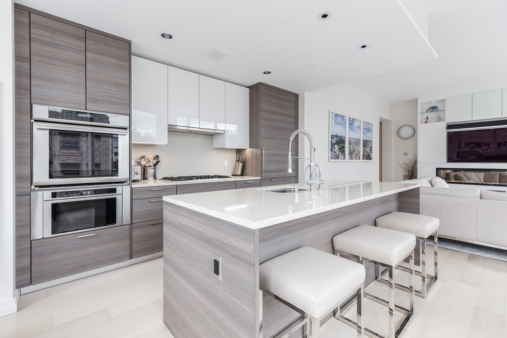1 Franklin Street, Unit 1004 Boston, MA 02110 - Photo 10 of 24 a kitchen with a stove a sink and a refrigerator