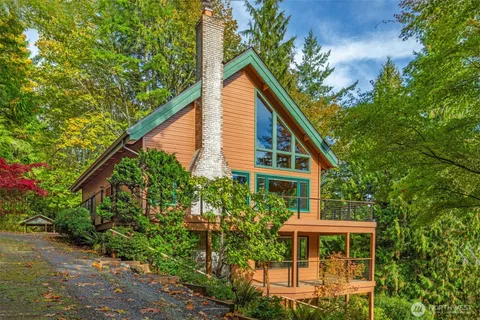 a backyard of a house with table and chairs under an umbrella