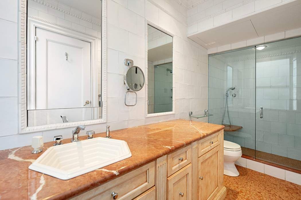 1040 5th Avenue, Unit 3A Manhattan, NY 10028 - Photo 12 of 16 a bathroom with a granite countertop sink mirror vanity and toilet