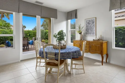 a dining room with furniture and a floor to ceiling window
