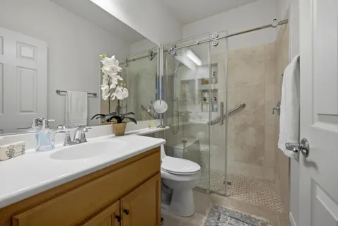 a bathroom with a sink mirror toilet and shower