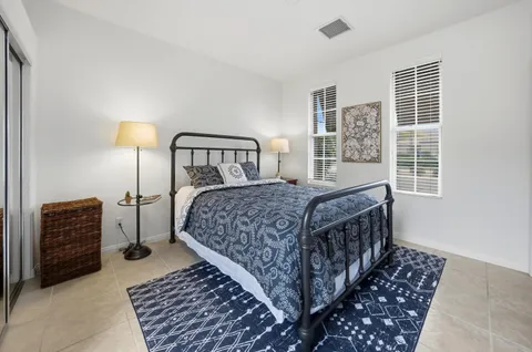 a bedroom with a bed a lamp and a large window