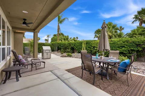 a view of a patio with a table and chairs and potted plants