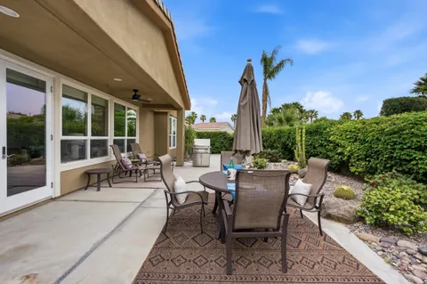 a view of a patio with couches table and chairs and potted plants